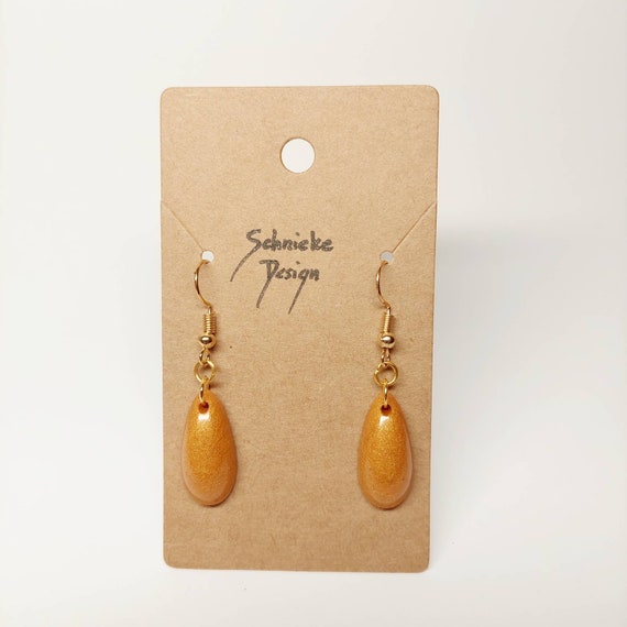 Earrings made of golden epoxy resin in drop form