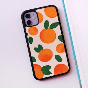 May include: A white phone case with a pattern of orange fruit and green leaves. The case has a black border and a cutout for the camera lens.