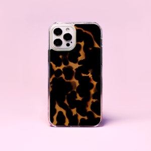 May include: A clear phone case with a brown and black tortoiseshell pattern. The case has a raised camera bump with three lenses.