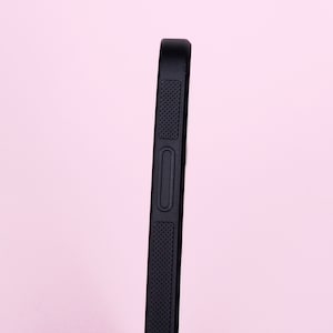 May include: A black phone case with a textured grip and a button on the side.