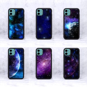 May include: Six black phone cases displaying space-themed designs. The cases showcase nebulae, galaxies, and planets in blue, purple, and white hues. Each case has a black border and a camera aperture.