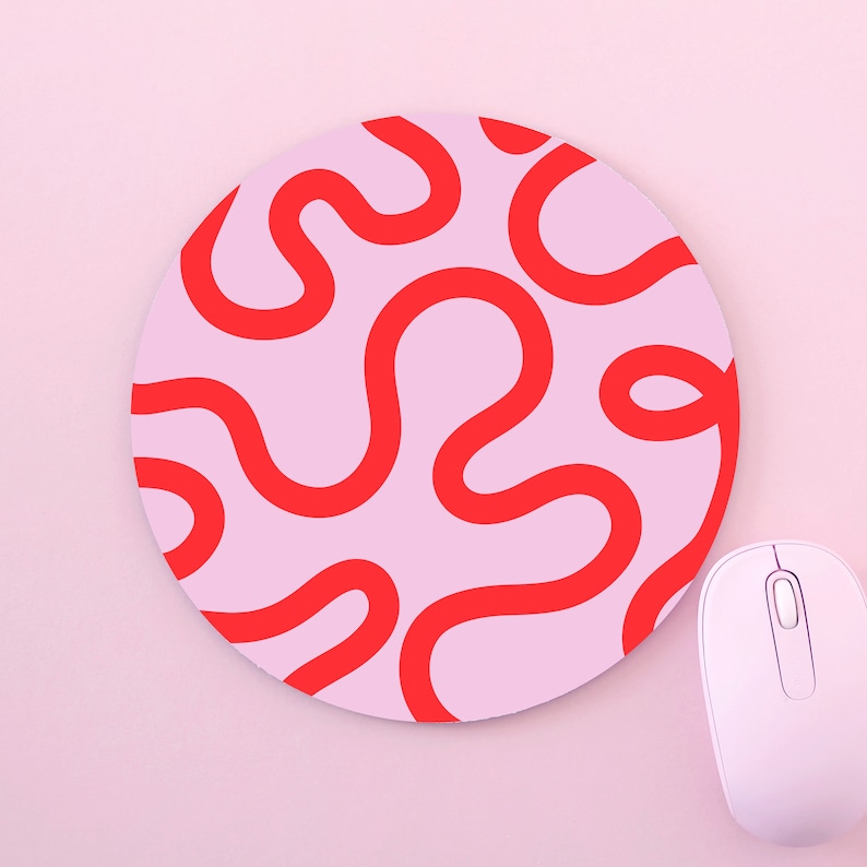 Peut inclure: Un tapis de souris rond rose avec un motif abstrait rouge. Le tapis de souris est sur une surface rose.