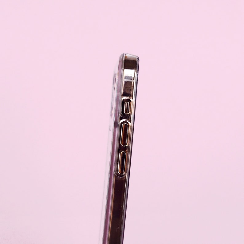 May include: A clear phone case with a gold trim around the edges. The case has cutouts for the phone's buttons and camera.