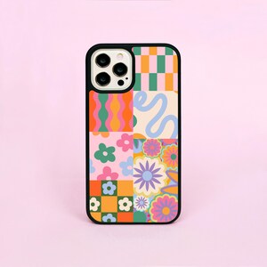 May include: A black phone case featuring a vibrant patchwork design. The design incorporates orange, pink, green, and blue floral and geometric patterns. The case has a black border and a camera aperture.