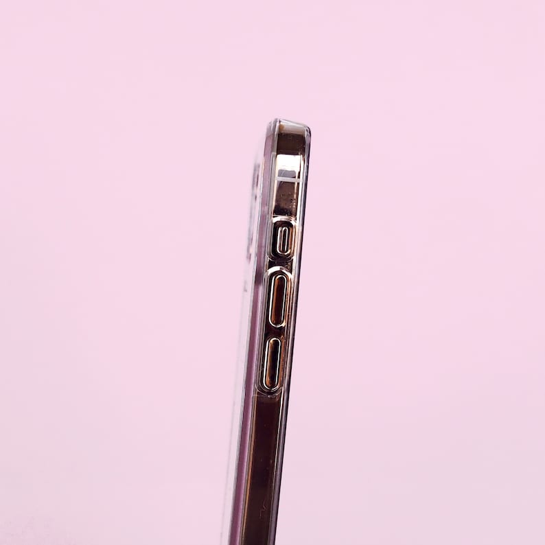 May include: A clear phone case with a gold trim around the edges. The case has cutouts for the buttons and camera.