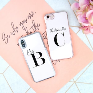 May include: Two clear phone cases with black lettering. One case says "The future Mrs. C" and the other says "Mrs. B".