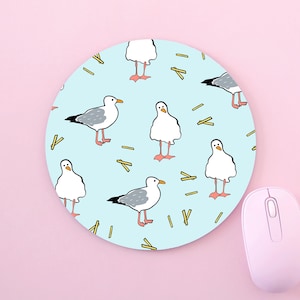 May include: A round blue mouse pad with a repeating pattern of white seagulls and yellow french fries.