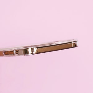 May include: A clear phone case with a rose gold metal bumper. The case is designed to protect a smartphone.