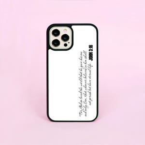 Op de afbeelding: Zwart-witte telefoonhoes met de tekst "For God so loved the world that he gave his one and only Son, that whoever believes in him shall not perish but have eternal life. JOHN 3:16". De hoes heeft een zwarte rand.