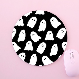May include: A black round mouse pad with a white ghost pattern. The ghosts have smiling faces and are scattered across the pad.