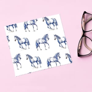 May include: White microfiber cleaning cloth with a repeating pattern of blue and white horses. The cloth is designed for cleaning glasses.