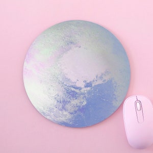 May include: A round blue and white iridescent mouse mat with a design resembling a planet. A white wireless mouse is on the right side of the image.