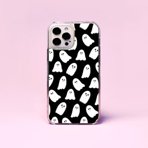 May include: A clear phone case with a black background and a white ghost pattern.