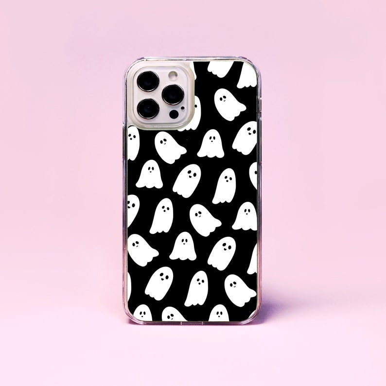 May include: A clear phone case with a black background and a white ghost pattern.