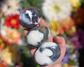 May include: Three smooth, polished agate stones with swirling black and white patterns. The stones are round and have a glossy finish.
