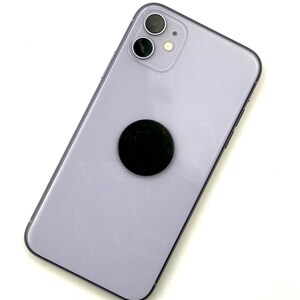 May include: A purple iPhone with a black phone grip attached to the back.