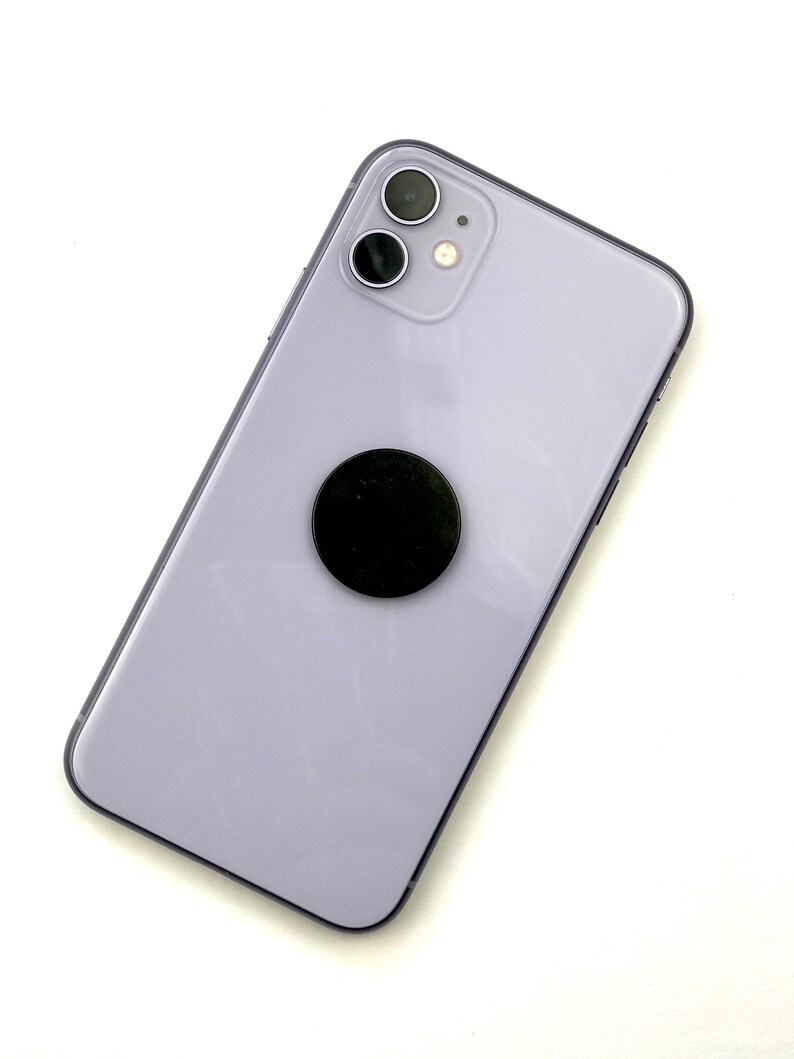 May include: A purple iPhone with a black phone grip attached to the back.