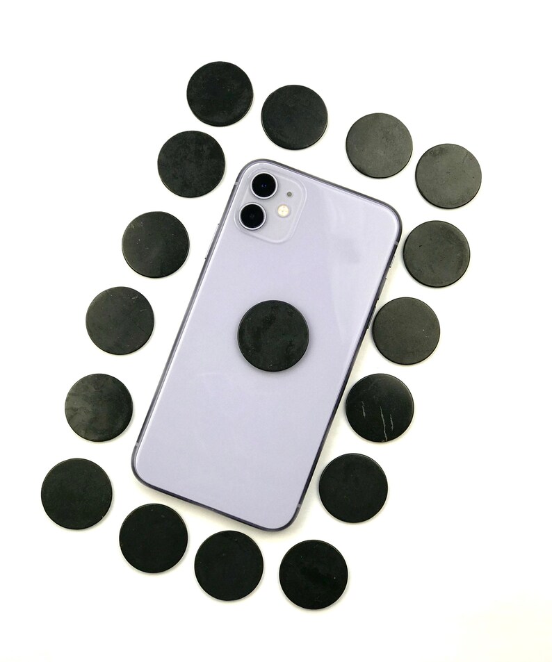 May include: A purple smartphone with a black magnetic phone ring holder surrounded by black round magnetic discs.