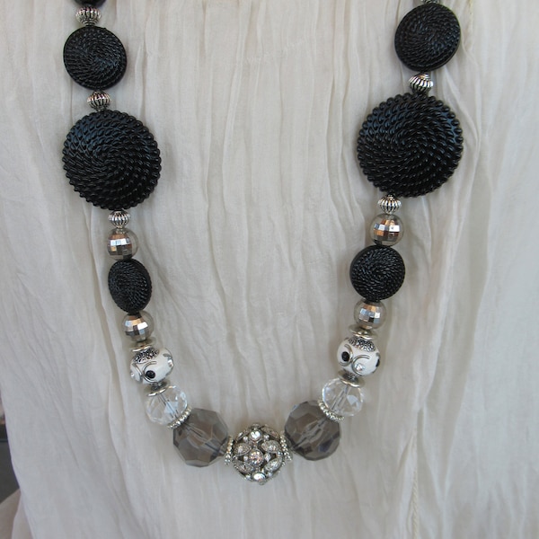 Tres joli sautoir noir et gris, cordon de suedine, perles synthetiques plates noir striée, perles disco, perles cristal, grosse perle strass