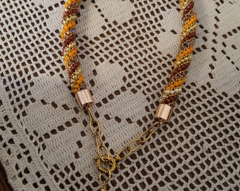 Collier court en spirale de perles tcheques, de perles myuki or, fermoir toogle avec pendentif coeur en verre ambré.