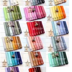 Puede incluir: Una colecci&oacute;n de 30 rollos de tela de fieltro en varios colores, incluyendo blanco, gris, verde, rosa, rojo, naranja, azul, marr&oacute;n, beige y morado. Los rollos est&aacute;n dispuestos en filas de seis, con cada rollo etiquetado con un n&uacute;mero.