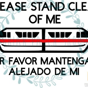 May include: A white and black graphic of a monorail with a red stripe. The text "PLEASE STAND CLEAR OF ME" is above the monorail and the text "POR FAVOR MANTENGASE ALEJADO DE MI" is below the monorail.