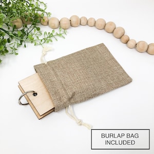 May include: A set of wooden blank tags with a silver ring, tied with a twine string and placed inside a burlap bag. The text "BURLAP BAG INCLUDED" is printed below the image.