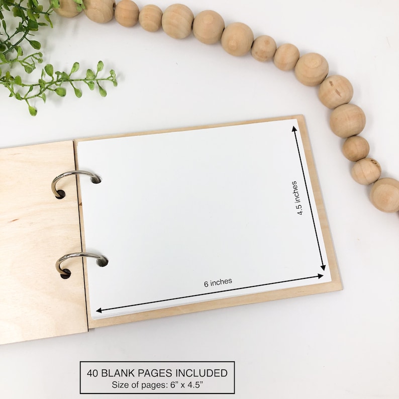 K&ouml;nnte beinhalten: Ein Journal mit Holzdeckel und 40 leeren Seiten. Das Journal ist ge&ouml;ffnet, um die wei&szlig;en Seiten zu zeigen. Das Journal misst 15,2 cm x 11,4 cm.