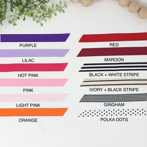May include: A collection of ribbon samples in various colors and patterns, including purple, lilac, red, maroon, hot pink, pink, light pink, orange, black and white stripe, ivory and black stripe, gingham, and polka dots.