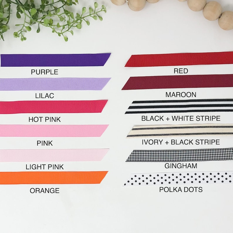 May include: A collection of ribbon samples in various colors and patterns, including purple, lilac, red, maroon, hot pink, pink, light pink, orange, black and white stripe, ivory and black stripe, gingham, and polka dots.