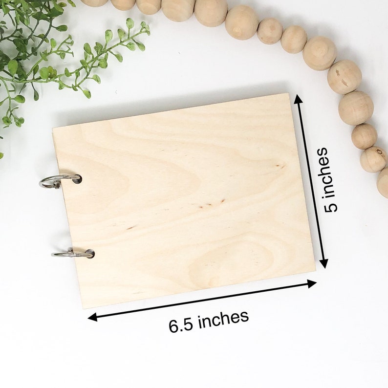 May include: A blank wooden journal with metal rings, measuring 6.5 inches by 5 inches.
