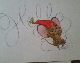 May include: A whimsical illustration of a mouse skiing downhill, wearing a red hat with a sprig of holly. The word "Joy" is written in cursive above the mouse. The mouse is smiling and appears to be enjoying the winter sport.