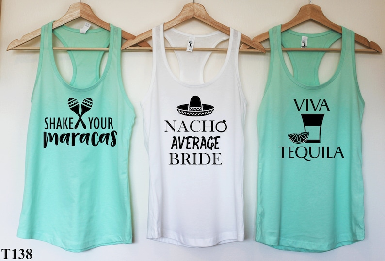 Puede incluir: Tres camisetas sin mangas con tem&aacute;tica de fiesta mexicana. La primera camiseta sin mangas es azul turquesa con el texto "Shake Your Maracas" y un par de maracas. La segunda camiseta sin mangas es blanca con el texto "Nacho Average Bride" y un sombrero. La tercera camiseta sin mangas es azul turquesa con el texto "Viva Tequila" y un vaso de chupito con una rodaja de lima.