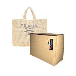 May include: A beige crochet tote bag with the text PRADA MILANO printed in dark gray on the front, paired with a rectangular tan felt bag organizer featuring a black fabric tag labeled Felt Bag Organizer and a small blue evil eye charm.