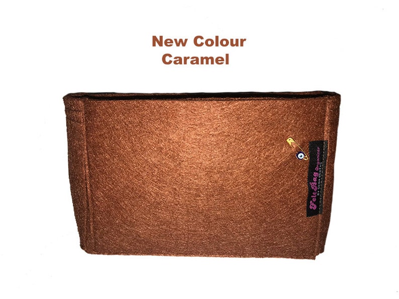 Puede incluir: Un inserto de bolsa de fieltro marr&oacute;n con un peque&ntilde;o amuleto azul de ojo turco y el texto "Felt Bag Organiser" en letras rosas.