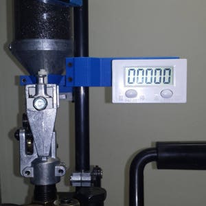May include: A blue and black reloading press with a digital scale attached. The scale reads "00000".