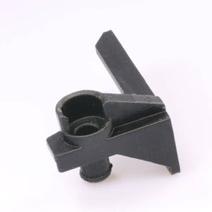 May include: Black plastic part with a round hole and a protruding tab. The part is designed to be attached to a surface.