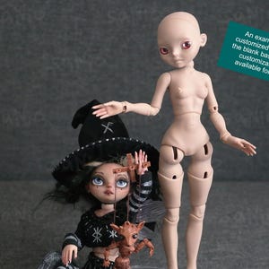 Puede incluir: Se muestran dos muñecas, una totalmente personalizada y la otra una base en blanco. La muñeca personalizada viste un atuendo temático de bruja, con un sombrero negro y una pequeña criatura marrón. La muñeca en blanco está desnuda y tiene un tono de piel claro.