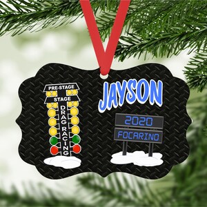 May include: Black and white Christmas ornament with a drag racing Christmas tree and a sign that says "Jayson 2020 Focarino".