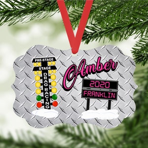 May include: A silver Christmas ornament with a drag racing Christmas tree and a sign that says "Amber 2020 Franklin".