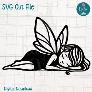 May include: Black and white SVG cut file of a sleeping fairy with detailed wings and flowing hair. The fairy is lying down, with the text "SVG Cut File" and "Digital Download" visible. A logo with the text "KayBee SVGs" is in the upper right corner.