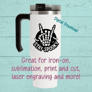 May include: White travel mug with a black handle and lid. The mug features a black and white design of a skeleton hand making a rock-and-roll gesture, with the words "STAY SPOOKY". Text on the mug says "Digital Download".