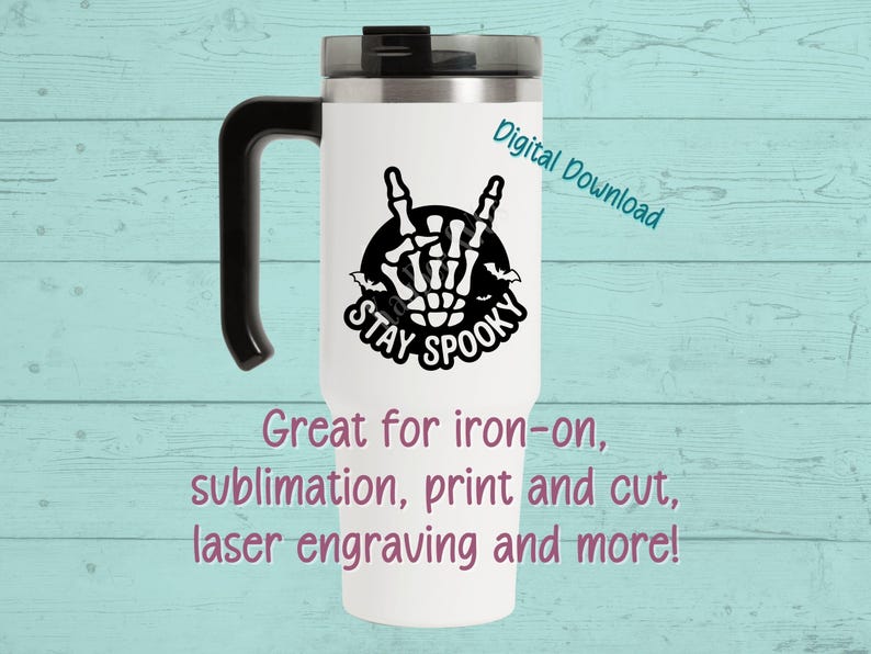 May include: White travel mug with a black handle and lid. The mug features a black and white design of a skeleton hand making a rock-and-roll gesture, with the words "STAY SPOOKY". Text on the mug says "Digital Download".