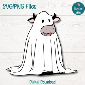 May include: A white cow wearing a ghost costume with black horns and a pink nose. The cow is smiling and has large, round eyes. The background is a white wooden plank wall.