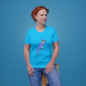 a woman in a blue shirt is sitting on a chair