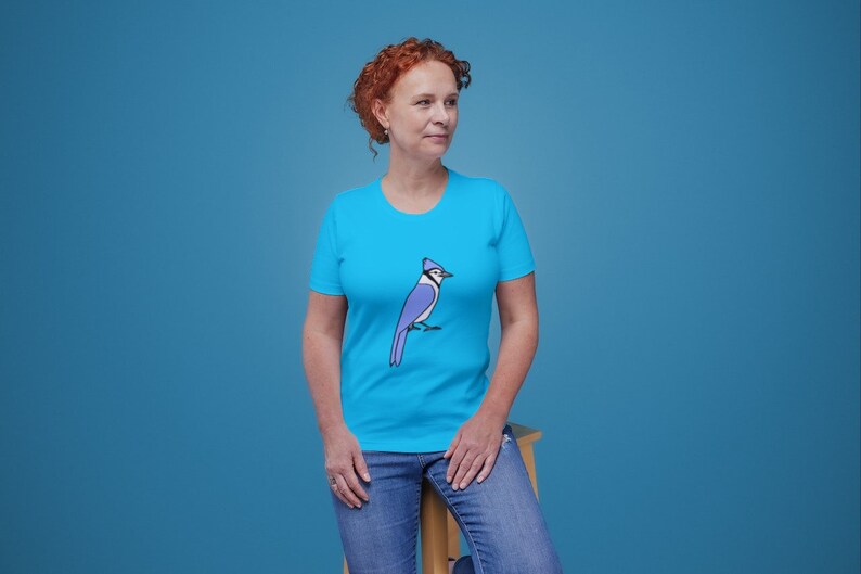 a woman in a blue shirt is sitting on a chair