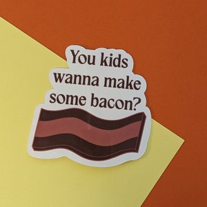 May include: White sticker with the text "You kids wanna make some bacon?" in brown lettering. A brown and white striped bacon graphic is below the text.