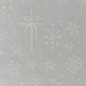 Puede incluir: Fondo blanco con copos de nieve, estrellas y un lazo en relieve y brillantes. El diseño presenta varias formas y tamaños de copos de nieve, junto con pequeños acentos de estrellas. El lazo tiene una línea vertical que se extiende hacia abajo.