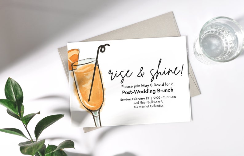 May include: A white card with a hand-drawn illustration of a mimosa cocktail. The text on the card reads "rise & shine! Please join May & David for a Post-Wedding Brunch Sunday, February 23 | 9:00 - 11:00 am 3rd Floor Ballroom A AC Marriot Columbus"