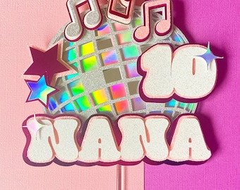 May include: A colorful cake topper with a disco ball, musical notes, and a star. The topper says "10 NANA" in a bubble font. The background is pink and purple.